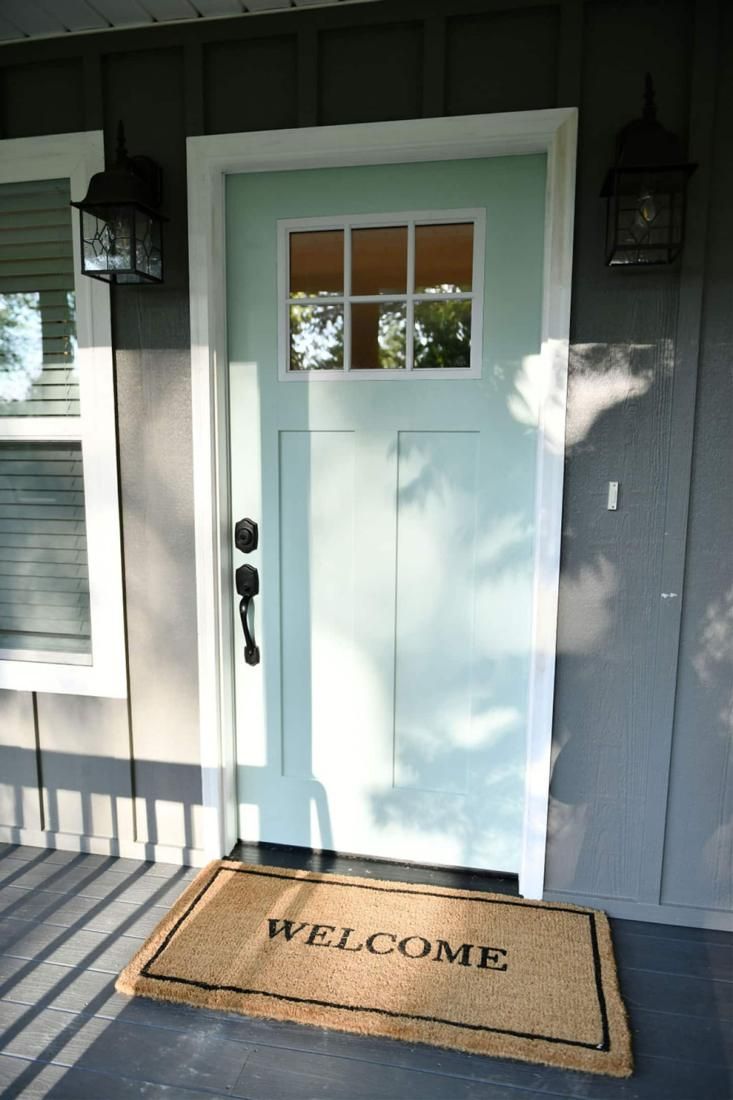 Mint-green front door with a welcome mat