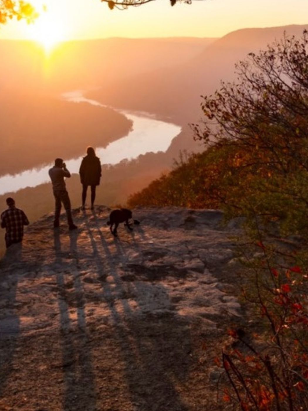 Hikers at a rocky overlook above the Tennessee River at sunset