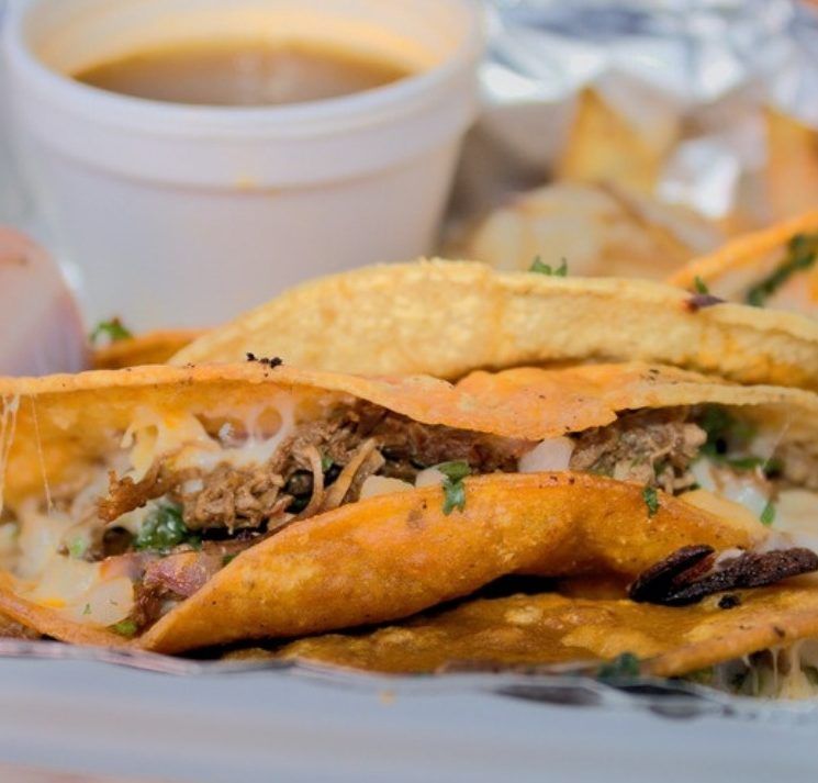 Crispy folded tacos with a cup of consomme