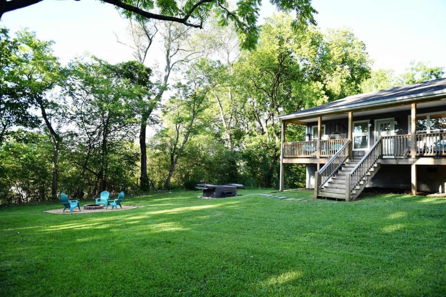 Wide lawn and the back of the house through the trees